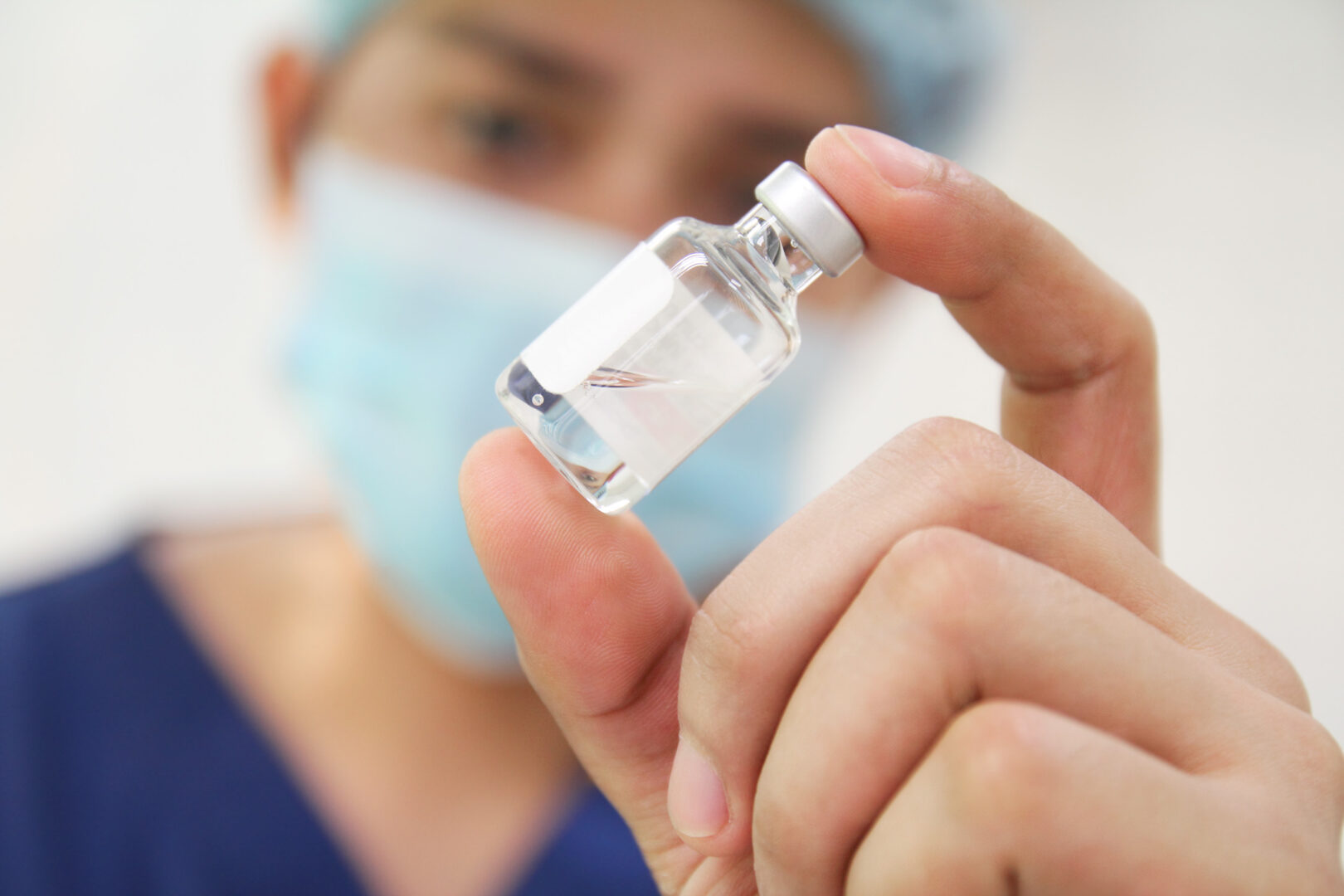Nurse,checking,a,vial,of,medicine.